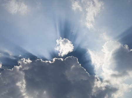 Sun is hiding behind a cloud with light streaks all around.