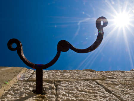 Old clutch fixed in a stone against the sun. Metaphor for freedomの写真素材