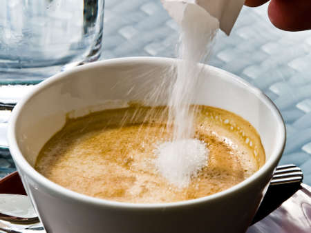 Adding sugar to the coffee cupの写真素材
