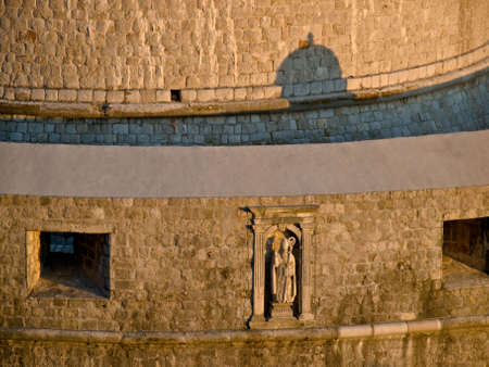 Dubrovnik old city walls details with sculpture at sunset - fortress Minceta.の写真素材