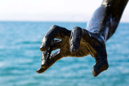 Hand covered with mud from Dead sea, Jordan. Skincare treatment. Use of high depth of field to blur the background.の写真素材