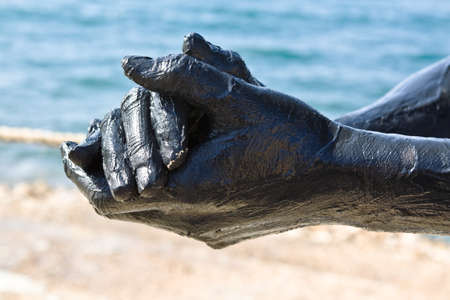 Hand covered with mud from Dead sea, Jordan. Skincare treatment. Use of high depth of field to blur the background.の写真素材
