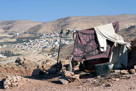 Petra - Nabataeans capital city (Al Khazneh) , Jordan. Bedouin tent with  new village in background at distance. Roman Empire period.の写真素材