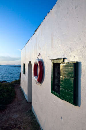 Lifebelt hanging on the wall at sunsetの写真素材