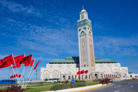 Flags of Morocco waving in the wind and King Hassan II mosque in Casablanca.の写真素材