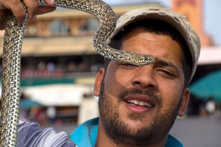 MARRAKESH, MOROCCO - OCTOBER, 22, 2010: Snake charmer on a Marrakesh main square with water snake.のeditorial素材