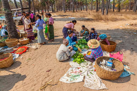 BAGAN, MYANMAR - FEB 24: Women are selling vegetables at the local market on Feb 24, 2012 in Bagan, Myanmar.のeditorial素材