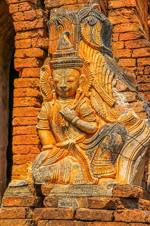 INDEIN, MYANMAR - FEBRUARY 28: Ruined statue at the entrance of the ancient Stupas at Indein overgrown with plants on February 28, 2013 in Indein, Myanmar.のeditorial素材