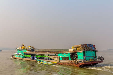 MANDALAY - FEBRUARY 26: Transport ship transporting goods across the Irrawaddi river on February 26, 2013 in Mandalay, Myanmar.のeditorial素材