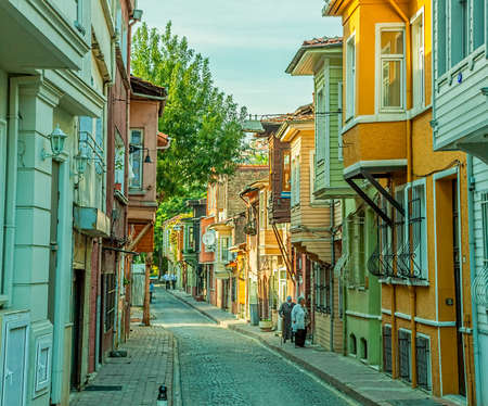 ISTANBUL, TURKEY - SEPTEMBER 27: People walking on street with old traditional wooden houses and filigree sidewalk in Golden horn district on September 27th, 2013 Istanbul, Turkey.のeditorial素材