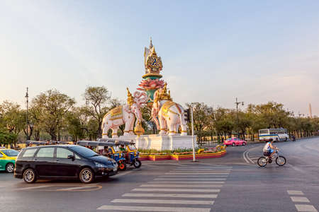 BANGKOK, THAILAND, MARCH 2, 2013: Cars wait at traffic lights at the turn of the road next to a sculpture of elephants.のeditorial素材