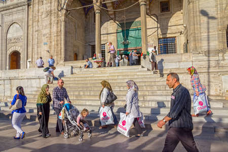ISTANBUL, TURKEY - SEPTEMBER 26, 2013: Tourists and passers-by in the square in front of the entrance to the New Mosque (Yeni Cami) in the Eminonu district.のeditorial素材