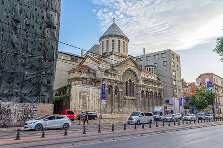 ISTANBUL, TURKEY - SEPTEMBER 28, 2013: The old Church of St Peter and St Paul surrounded by newer buildings, tram wire and road.のeditorial素材