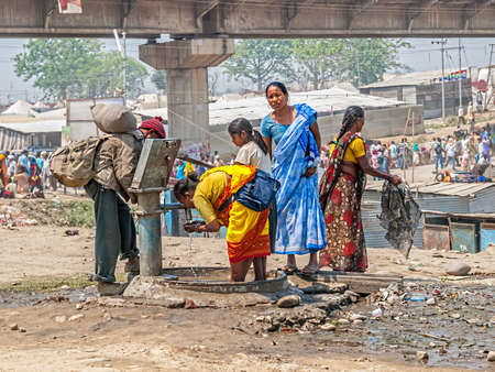 HARIDWAR, INDIA - APRIL 14, 2010: Women by the public tap washing and drinking at the Kumbh Mela, a mass Hindu pilgrimage of faith.のeditorial素材