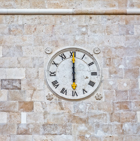 The old church stone clock at the wall in Supetar town center.