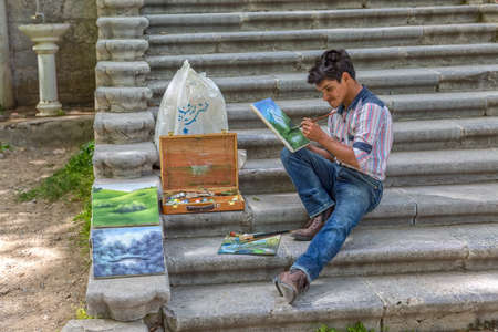 TEHRAN IRAN  MAY 1 2015: Painter painting in the park near the Green Palace Museum Sabz.のeditorial素材