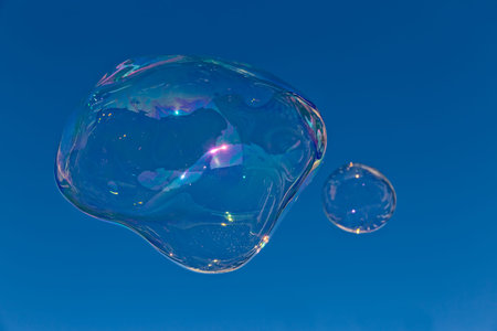 Big transparent soap bubble against blue sky.の写真素材