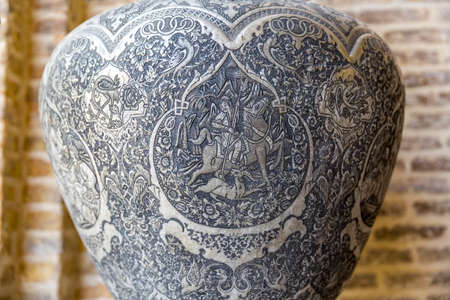 SHIRAZ, IRAN - MAY 2, 2015: Engraved stories from hunting on a metal vase, traditional souvenir from Persia on Vakil Bazaar.のeditorial素材