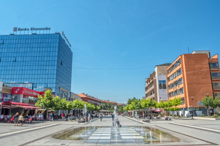 PRISTINA, KOSOVO - JULY 01, 2015: People walking by the new fountain on Scanderbeg square in city center.のeditorial素材