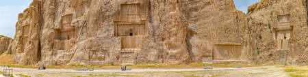 NAQSH-E RUSTAM, IRAN - MAY 3, 2015: Tourists sightseeing the historical monuments of ancient necropolis near ruins of old city Persepolis.のeditorial素材