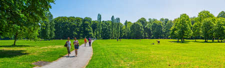 MUNICH, GERMANY - JUNE 4, 2015: Panoramic view of the people enjoying the sunny day by walking in English garden, famous city park.のeditorial素材