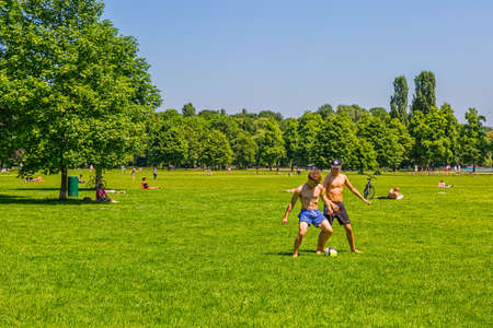 MUNICH, GERMANY - JUNE 4, 2015: People enjoying the sunny day with family and friends in English garden, famous city park.のeditorial素材