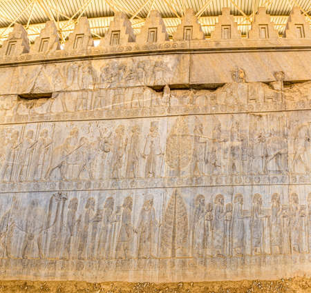 Stone bas-relief of residents of historical empire with animals carved on the stairway facade of the Apadana at the old city Persepolis.の写真素材