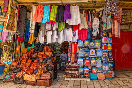 JERUSALEM, ISRAEL - JUNE 19, 2015: Vendor waiting for customers in the small shop of goods and souvenirs in the old town streets corner.のeditorial素材