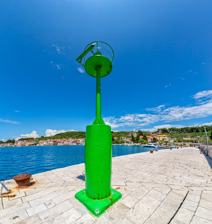 Green beakon at the end of a pier in the Prvic Luka port in Croatia.の写真素材