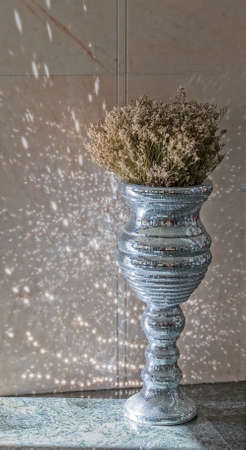 Silver disco mirror vase in hotel lobby.の写真素材