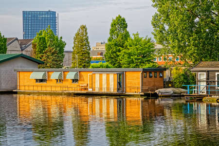 AMSTERDAM, NETHERLANDS - JUNE 12, 2016: Floating houses with reflection in a water canal of the river Amstel in Amsterdam Netherlands.のeditorial素材