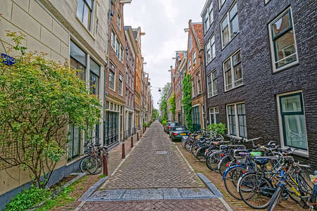 Amsterdam bicycles parked in old cobblestone streetのeditorial素材