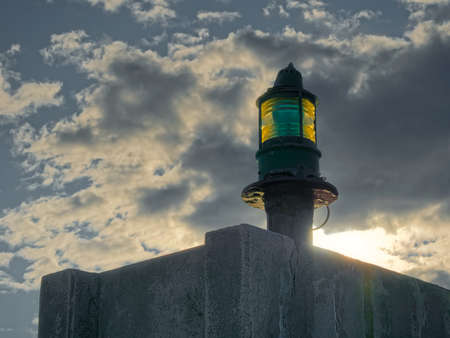 Lighthouse green beacon against cloudy skyの写真素材