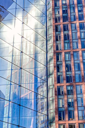 Facade with multiple reflections of other buildings and the sun in New Yorkの写真素材