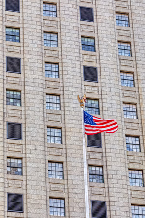 USA flag in New York, unfurled and fluttering, mounted on a city park yardarm.