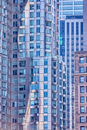 Architectural detail of the facade with multiple reflections of other buildings and the sun in New Yorkの写真素材