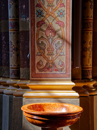 DJAKOVO, CROATIA - October 5, 2017: Old marble baptismal font at the entrance to the church of the...