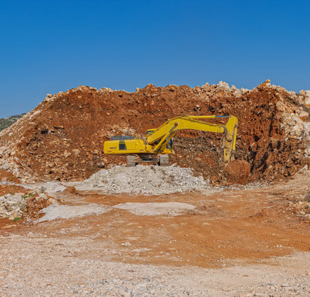 Yellow excavator at a road construction siteの写真素材