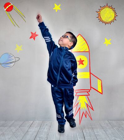 Kid with jet pack. Child playing at home. Success, imagination and innovation technology conceptの写真素材