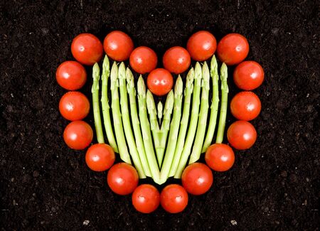 A heart shape made with tomatos and asparagusの写真素材