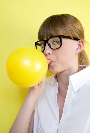 Young pretty girl blows up a balloonの写真素材