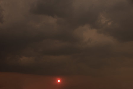 The sun and black rain clouds in the evening