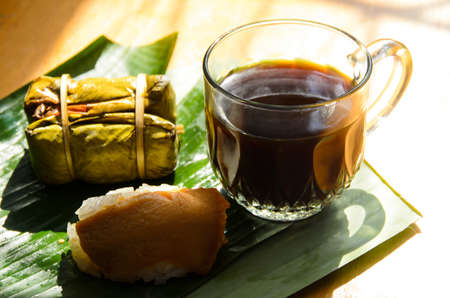 Black coffee with custard sticky rice And mush tied on banana leaves, concept to reduce the use of plasticの写真素材