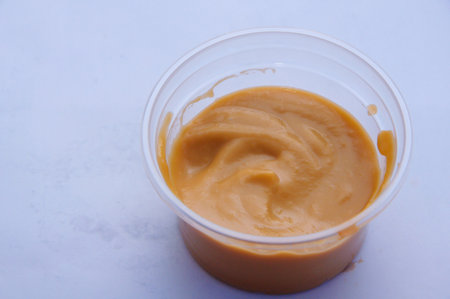 Custard cream in a transparent cup on a white backgroundの写真素材