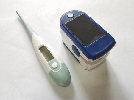 Body thermometer and fingertip oxygen meter on white background