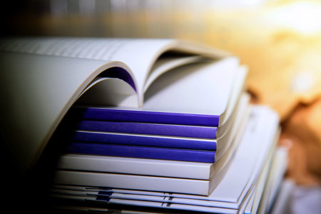 a pile of open books on a table in the university library
