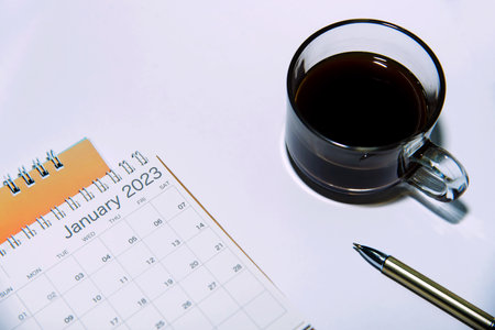 desk calendar Pen and black coffee cup on white background, isolated marketing concept and business planの写真素材