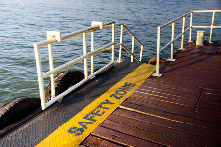 Yellow warning sign on the deck of a ferry in the water.