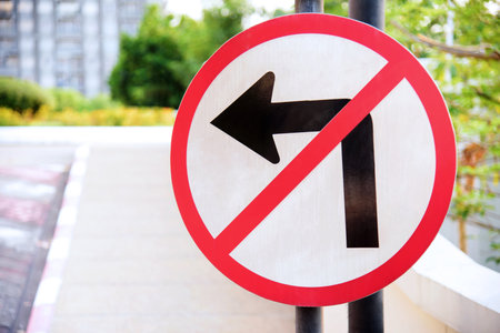 traffic sign prohibiting left turn on the road by the parkの写真素材