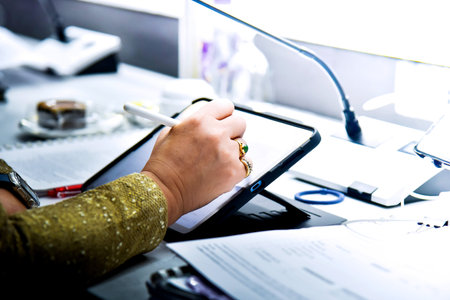 Close up of a businesswoman working on a tablet in an office